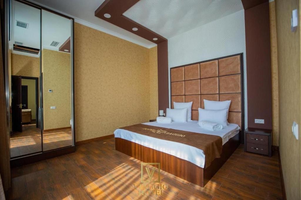 Un dormitorio con una cama grande y un espejo grande. en Hotel Viaggio, en Ereván