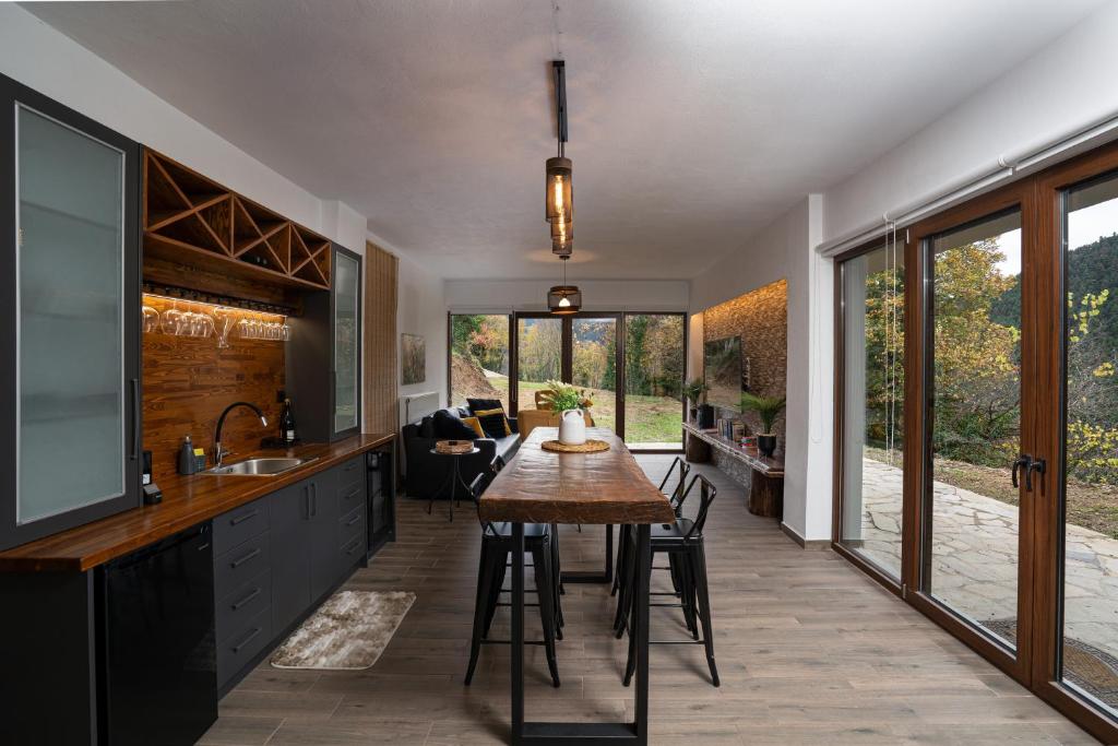 een keuken met een houten tafel en een aantal stoelen bij Villa Christina in Karpenisi