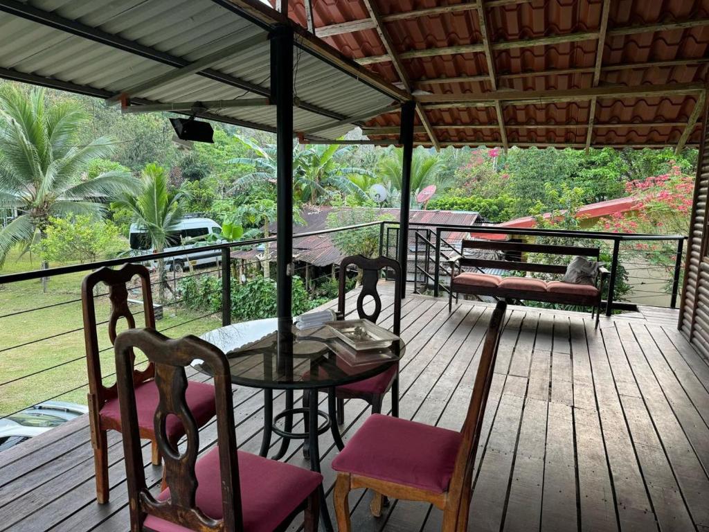 a wooden deck with a table and chairs on it at Cabañas Retiro Del Rio in Guayabal