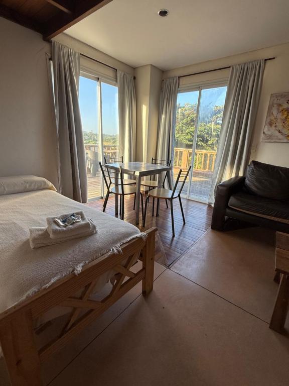 a bedroom with a bed and a table and chairs at Geko Apart Hotel in Mar del Plata