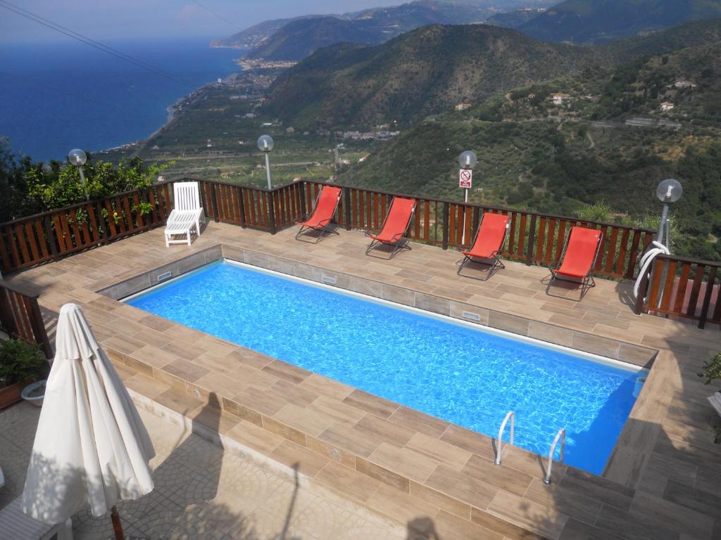 uma piscina com cadeiras e vista para o oceano em Villa Rosi em Naso