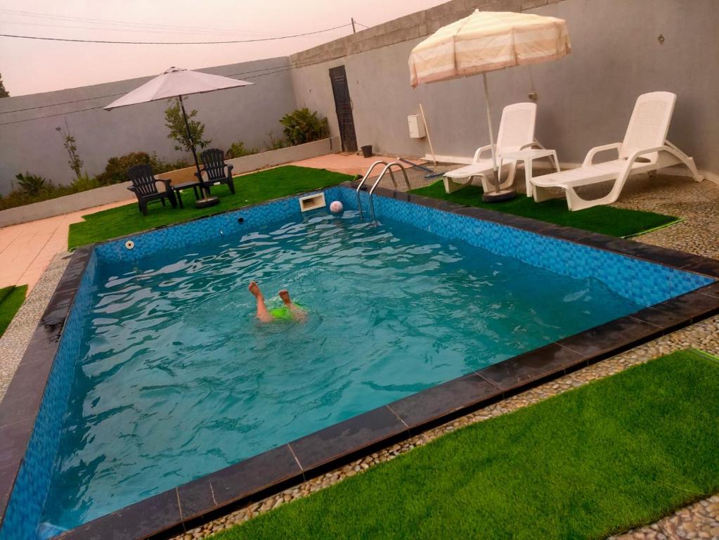 a person swimming in a swimming pool at Maison avec piscine pour famille au région de safi in Safi