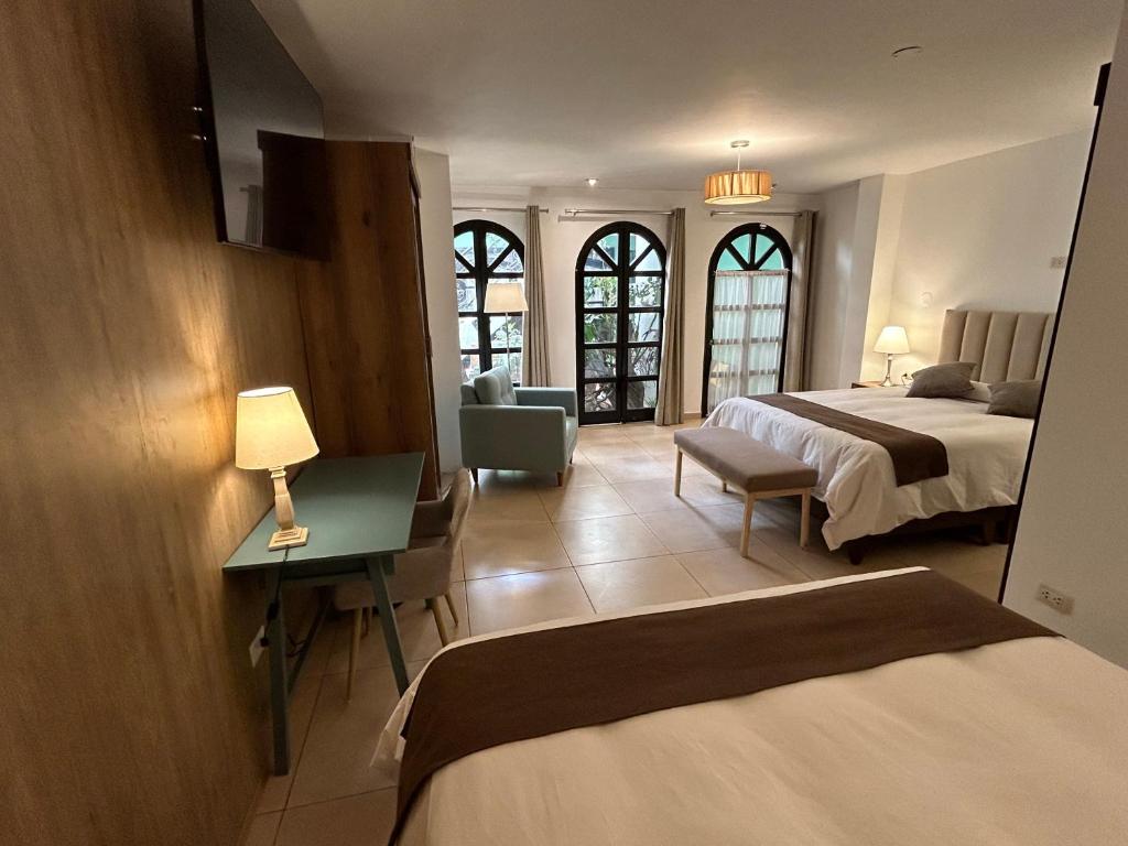 瓦拉斯Habitaciones La Casona的酒店客房带两张床、书桌以及一间客房。