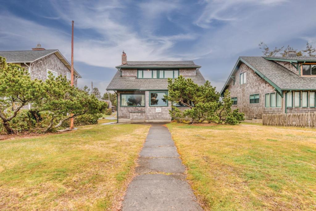a stone house with a pathway leading into a yard at The Tides in Seaside
