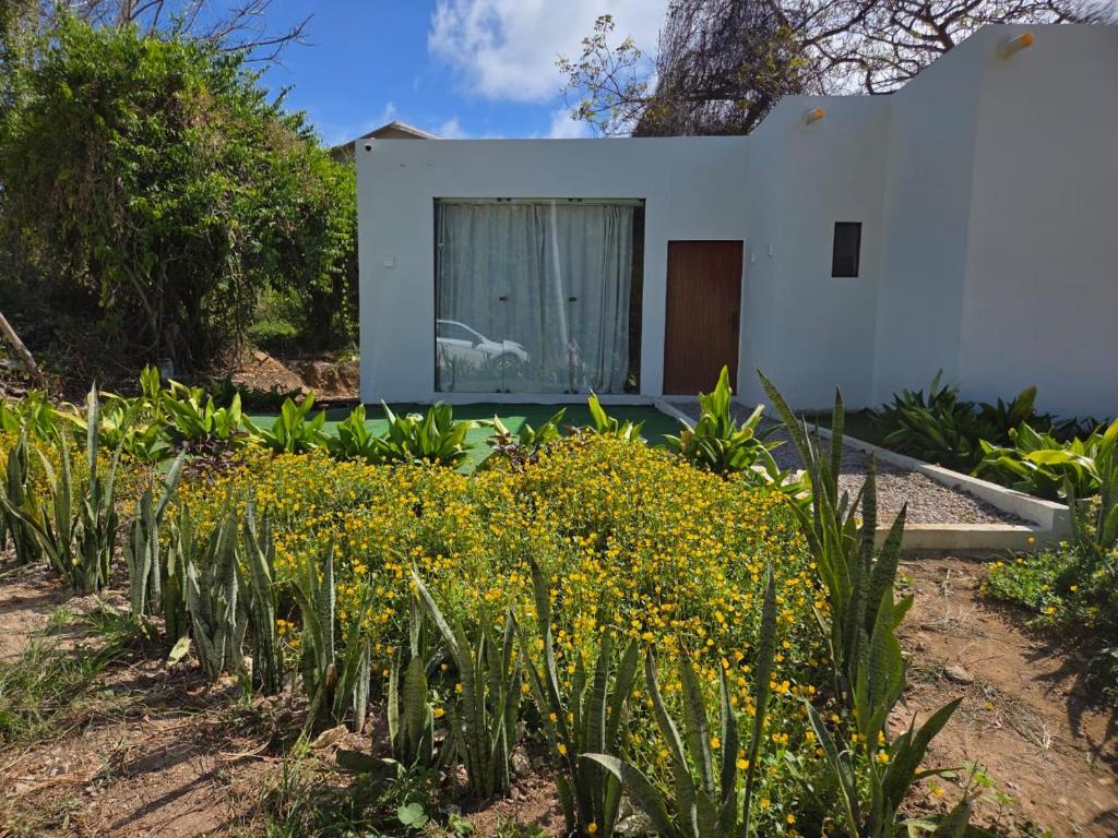 a white house with yellow flowers in front of it at Casa Mirafeliz in Fernando de Noronha