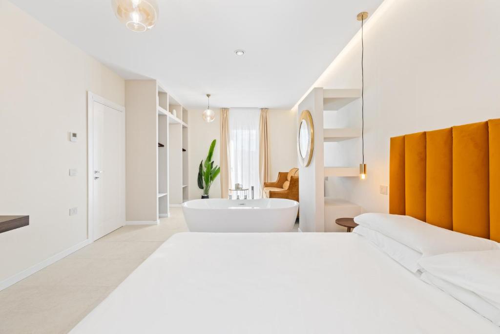 a white bathroom with a large bed and a bath tub at Sofì Luxury Suite in Iglesias