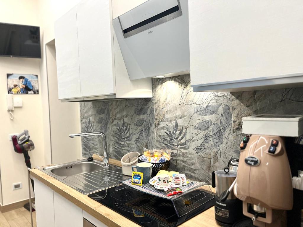 a kitchen with white cabinets and a sink at Arenaccia House Naples Center Welcome Wine in Naples