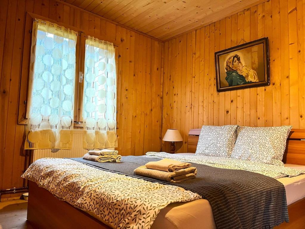 a bedroom with a bed with towels on it at Memory Lane Cottage – Posada in Comarnic