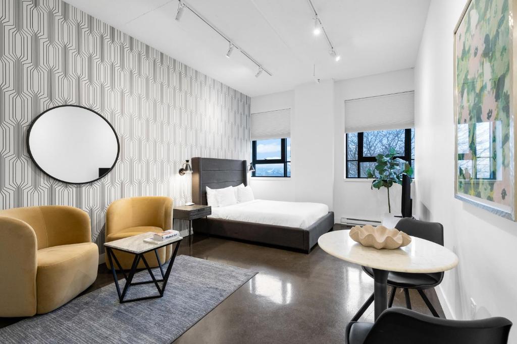 una sala de estar con una cama y una mesa en Le William, en Montreal