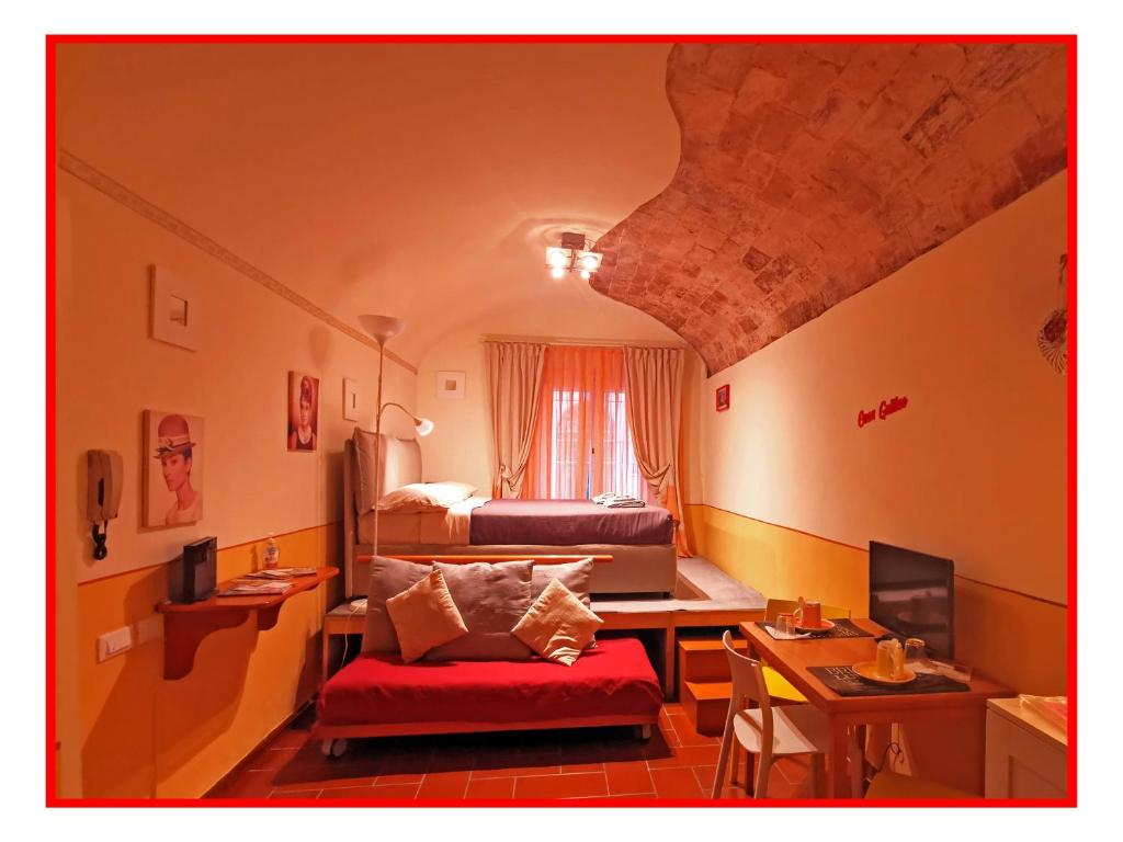 a small room with two beds and a red couch at Casa GALILEO- Antiche Dimore Pisane in Pisa