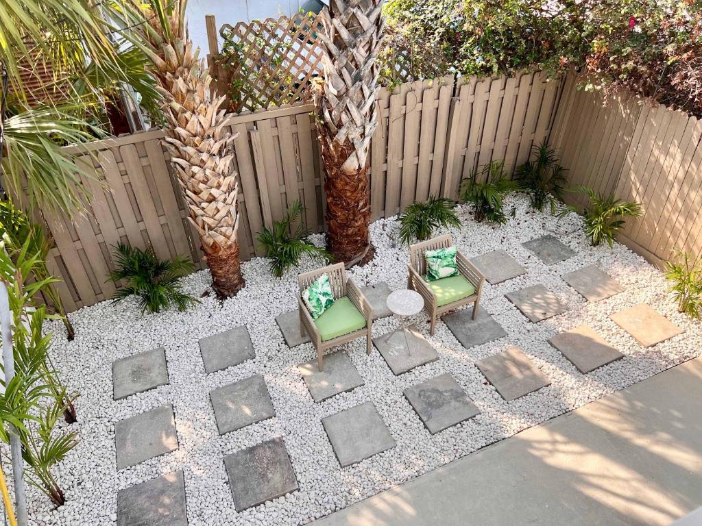 a patio with two chairs and a table and a fence at Coastal Countdown Relaxed Townhome Near Beach and Rockets in Cape Canaveral