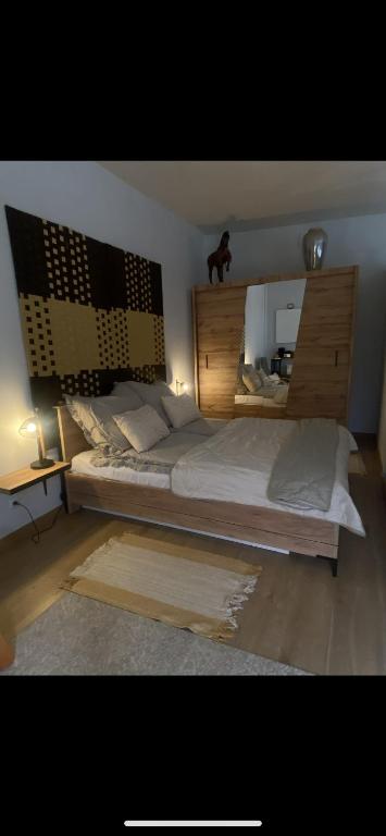 ein Schlafzimmer mit einem großen Bett mit einem hölzernen Kopfteil in der Unterkunft Cozy apartment with terrace in Malbork