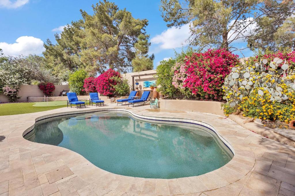 una piscina in un cortile con sedie e fiori di Modern, Upgraded, Resort-Style a Chandler