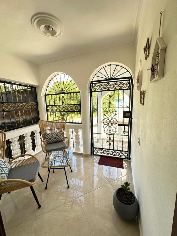 a living room with two chairs and two windows at Modern and fully equipped house in Samaná in Santa Bárbara de Samaná