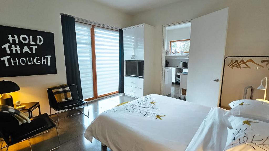 una camera da letto con un letto bianco e una finestra di The Cube Cow Bay Suite a Cowichan Bay