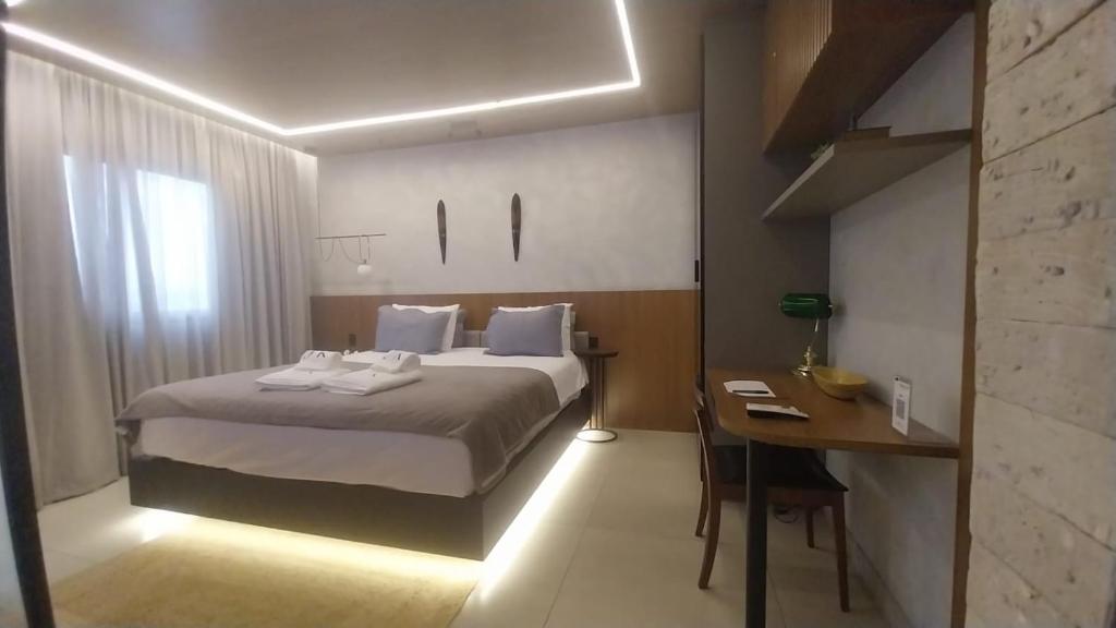 Una habitación de hotel con una cama y un escritorio con un escritorio en Flat JK Luxo, en Ribeirão Preto