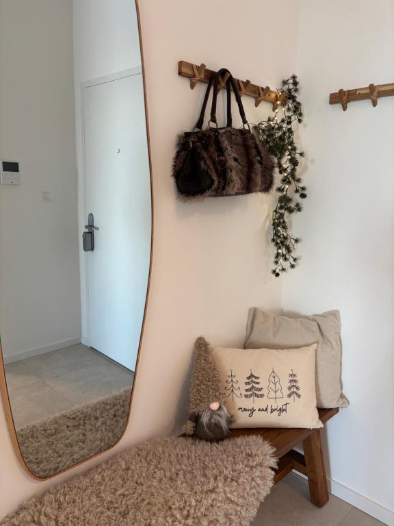 BankaBluewave boho apartment Slnava的墙上挂着一面镜子，旁边是一张长凳和一个枕头。