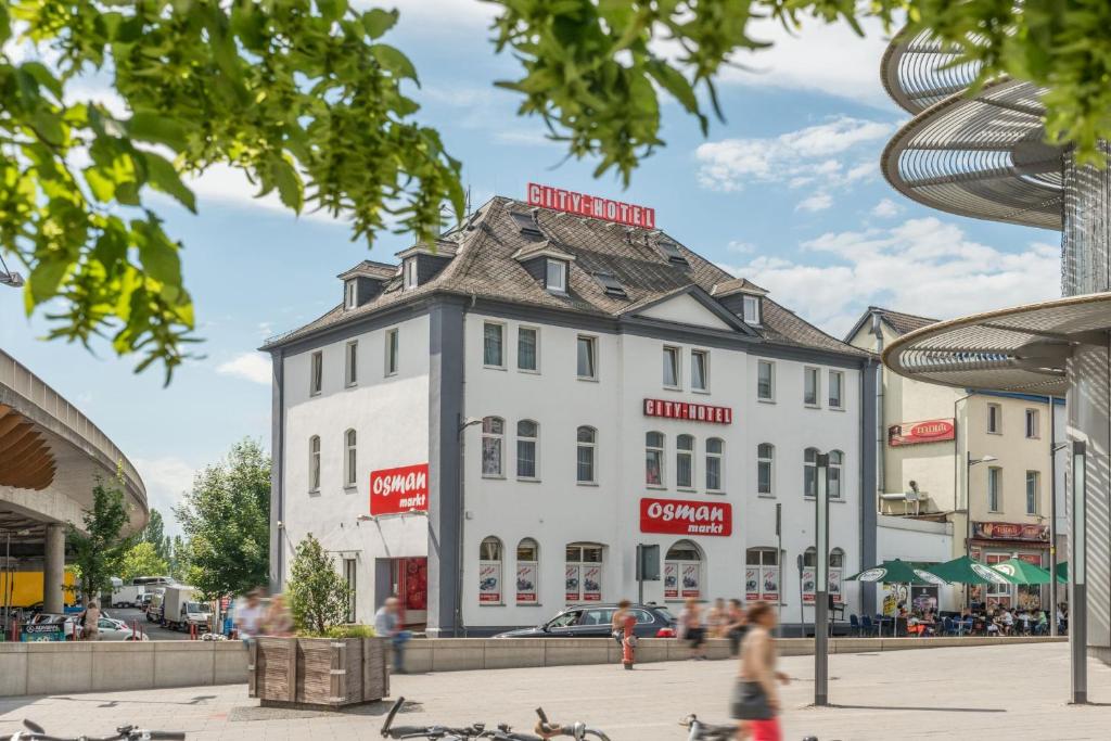 ein großes weißes Gebäude mit grauem Dach in der Unterkunft City Hotel Wetzlar in Wetzlar