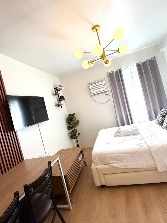 ein Schlafzimmer mit einem Bett und einem Esstisch in der Unterkunft Luzera Escape - a minimalist and cozy studio unit in Davao City