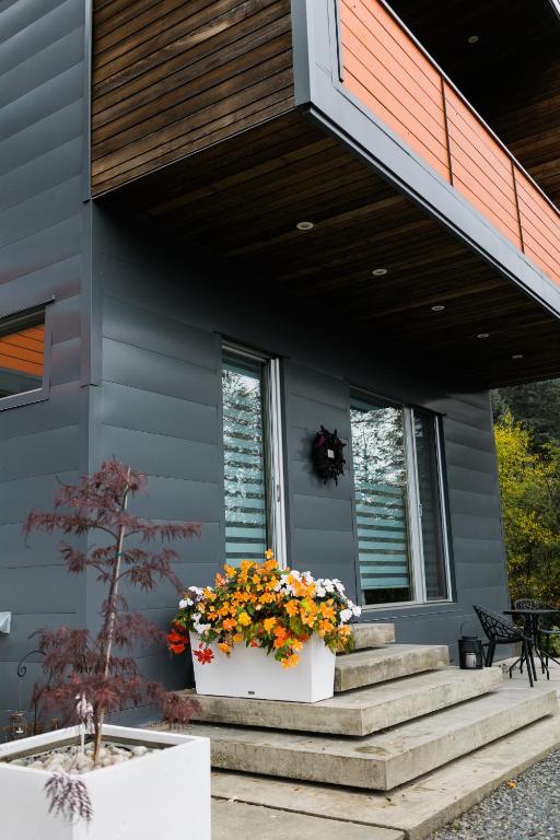 a house with a flower pot on the stairs at The Cube Cow Bay Suite in Cowichan Bay