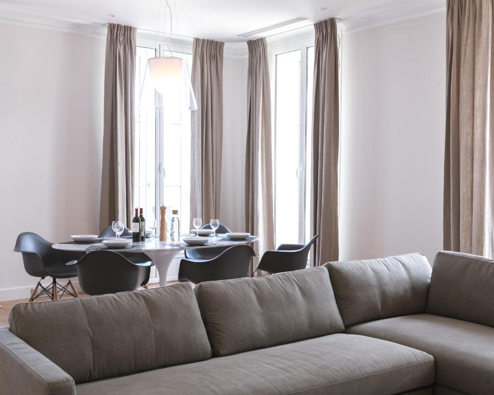 ein Wohnzimmer mit einem Sofa und einem Tisch in der Unterkunft Appartement T4 cours de l'intendance in Bordeaux