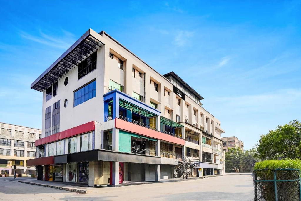 Un edificio de apartamentos con ventanas de colores en una calle. en Collection O Infocity Metro Station Gandhinagar Formerly Hotel LLP, en Gandhinagar