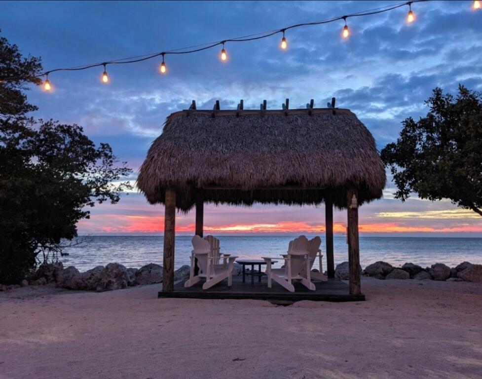 キーラーゴにあるDay Dreams Key Largoのビーチにある椅子とライトを備えたガゼボ