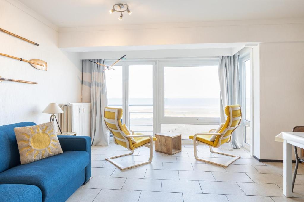een woonkamer met een blauwe bank en gele stoelen bij Sun Beach 0201 in Sint-Idesbald