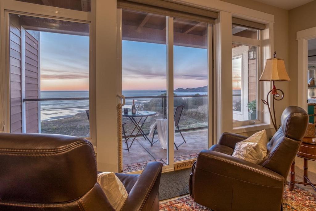 a living room with chairs and a view of the ocean at Sunsets at the Shoreline in Newport