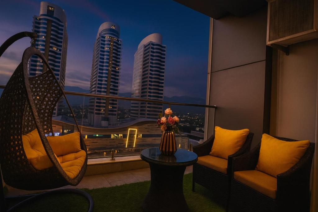 a balcony with chairs and a view of a city at Elysium Tower Premium Serviced Apartments Facing Centaurus Mall Islamabad in Islamabad
