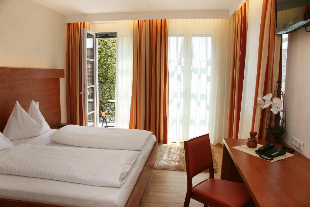 a hotel room with a bed and a desk and a desk at Hotel Grazerhof in Bad Gleichenberg