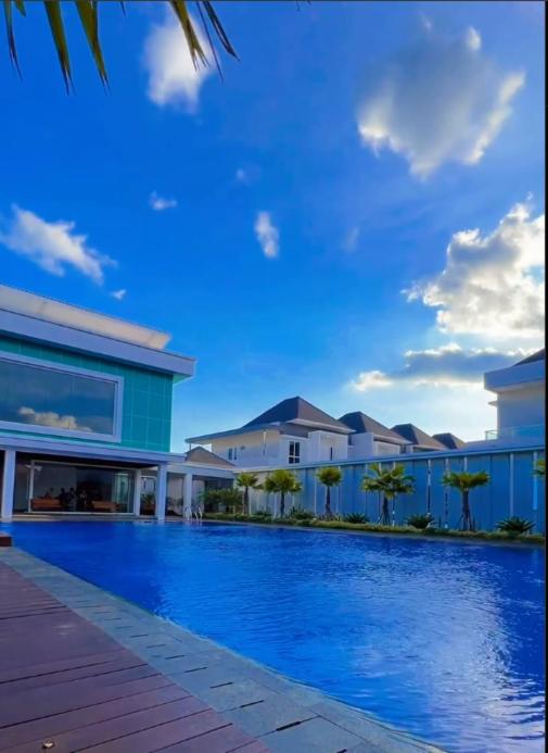 a large blue swimming pool in front of a building at Rumah Cluster Springwood1 in Pontianak