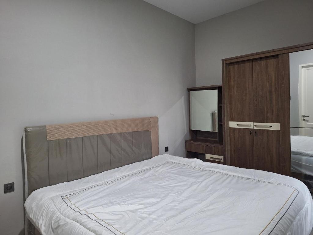 una camera da letto con un letto, un comò e uno specchio di Cluster Springwood a Pontianak