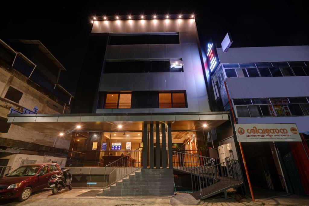 a building with a car parked in front of it at Super Townhouse Edasserys Sea Pearl in Cochin