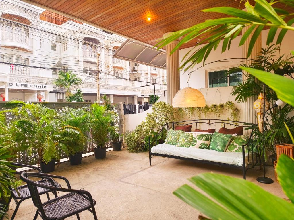 a patio with a bed and plants in a building at Danita's Home Bangkok in Bangkok