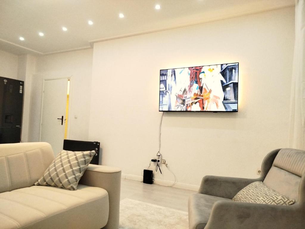 een woonkamer met een flatscreen-tv aan de muur bij CityPark BnB in Pristina