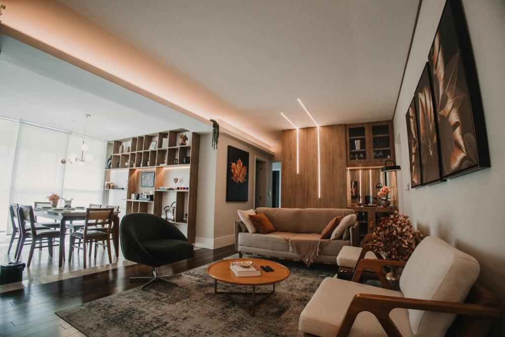 a living room with a couch and a table at Superitá Campos do Jordão - Apto de alto padrão com estrutura de resort perto do Capivari e Morro do Elefante in Campos do Jordão