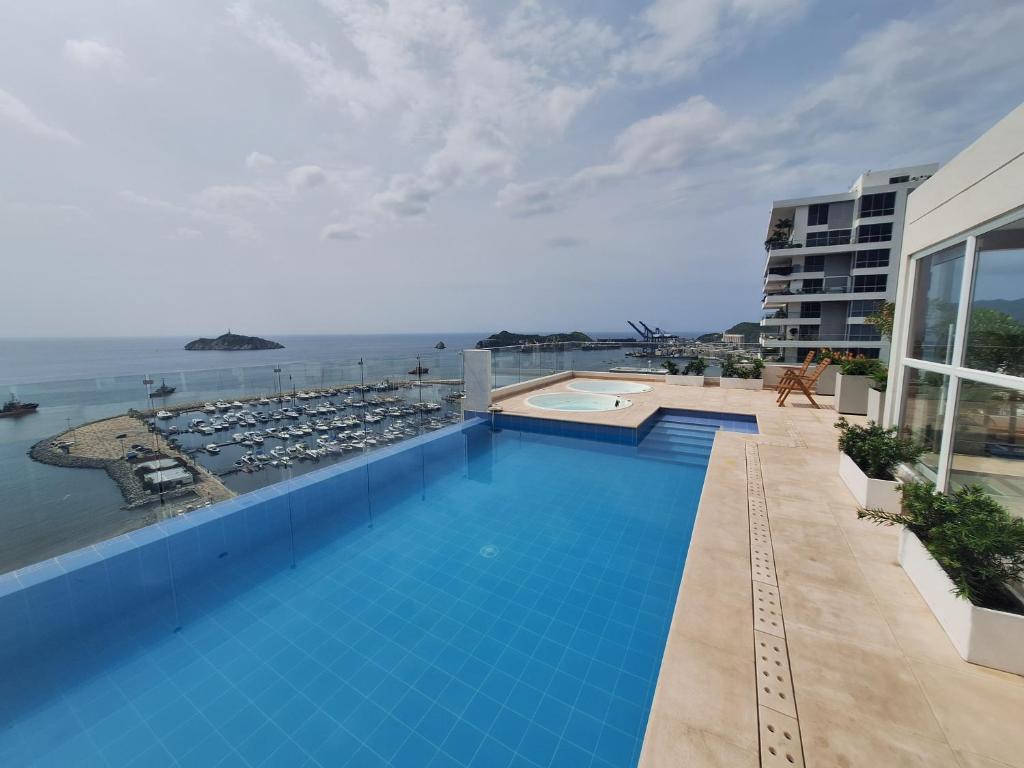 a swimming pool with a view of the ocean at Nuevo Apartaestudio en frente de la marina in Santa Marta