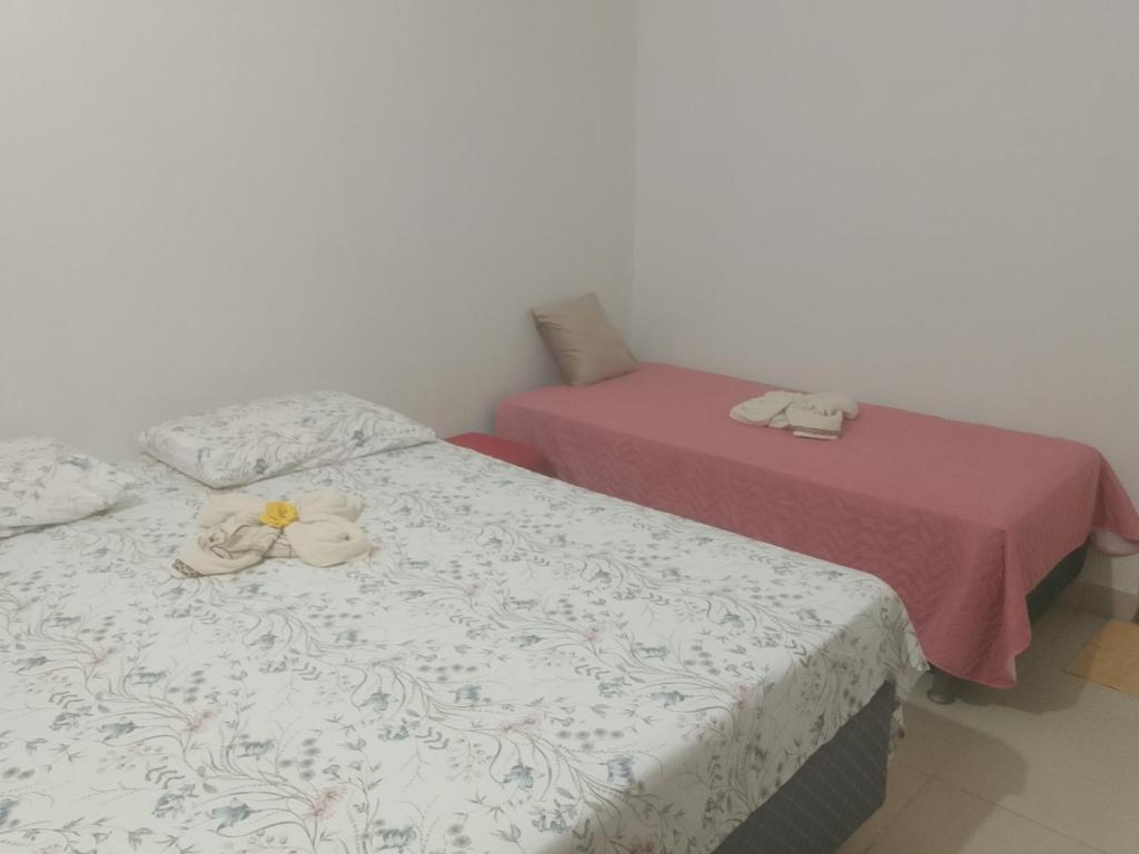 two beds with towels on top of them in a room at Cantinho da Rosa in Santo Amaro