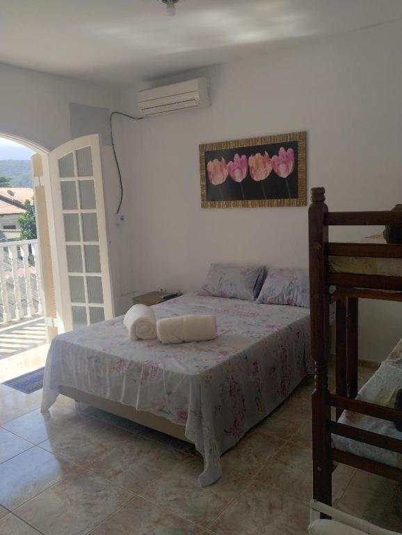 a bedroom with a bed with pink flowers on the wall at Novo Encanto in Ubatuba
