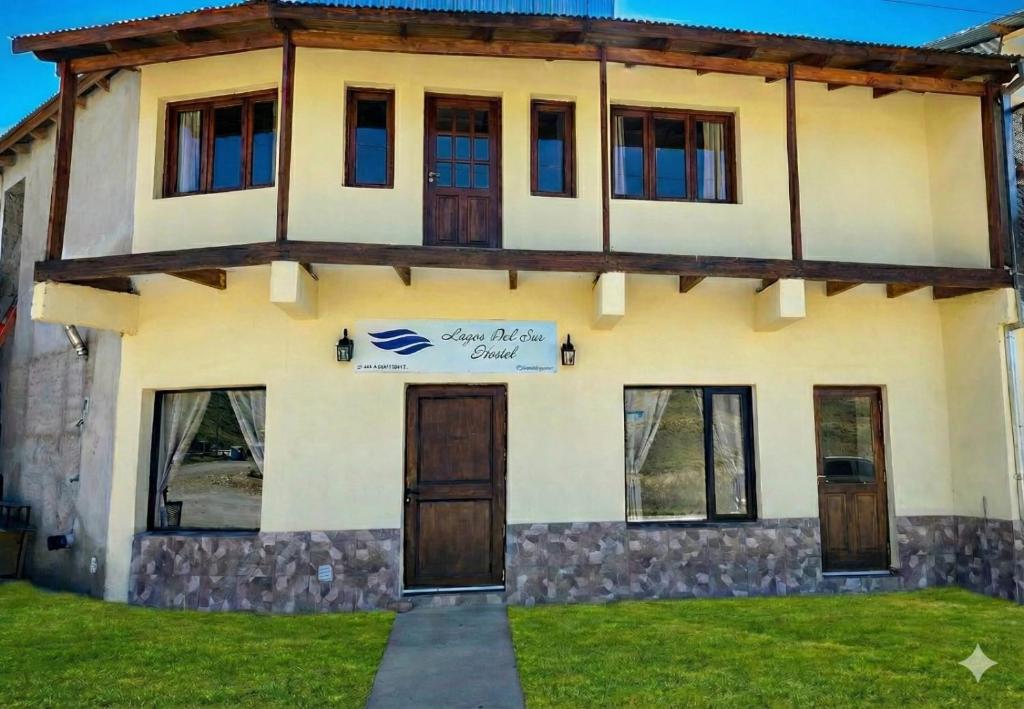 una casa con un cartello sulla parte anteriore di Hostel Lagos del Sur a El Chalten
