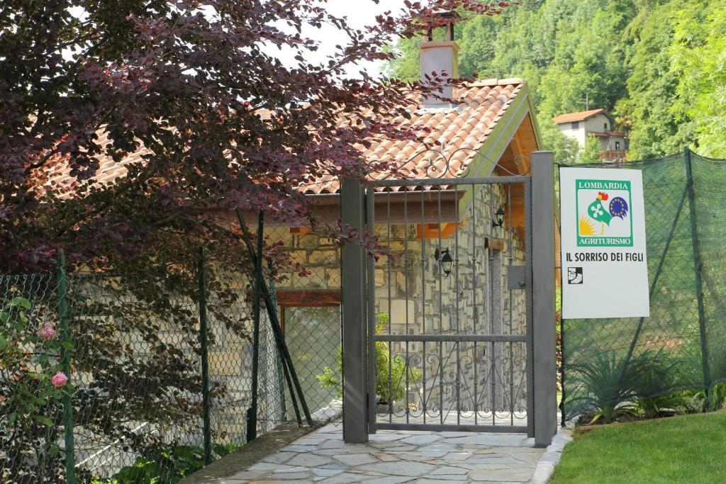 a gate to a house with a sign on it at Agriturismo Il Sorriso dei Figli in Argegno