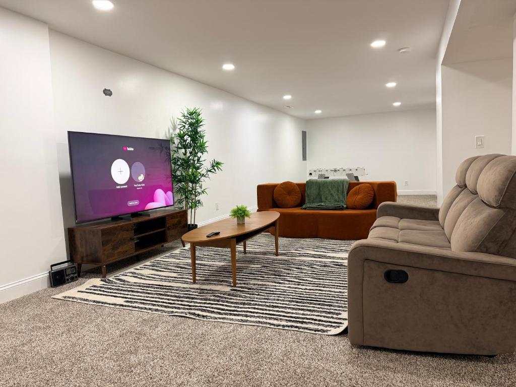 Una sala de estar con un sofá y un televisor de pantalla plana. en Relaxing Getaway, en Upper Marlboro