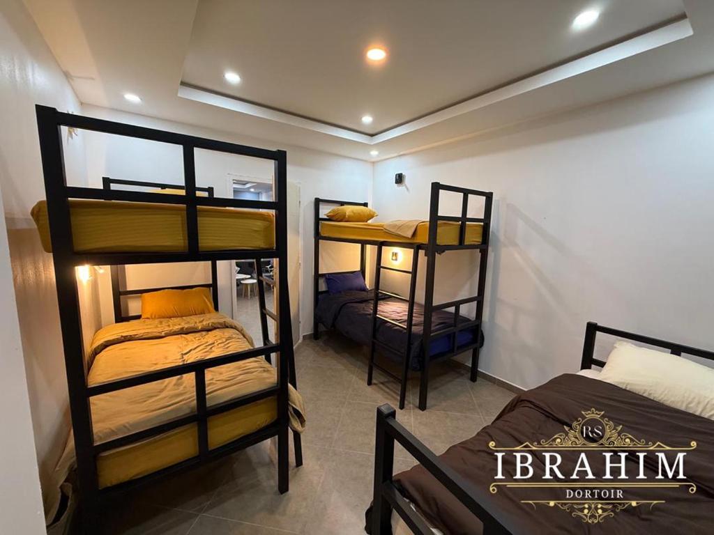 een kamer met 3 stapelbedden in een kamer bij Dortoir Ibrahim in Tébessa