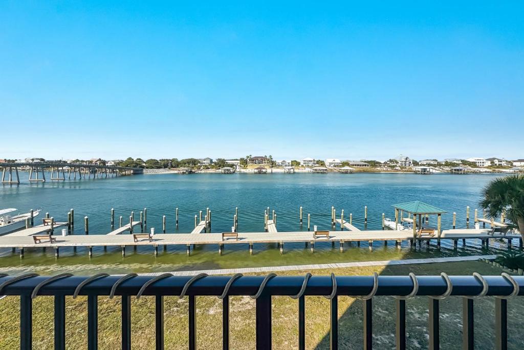 a view of a dock with tables and benches on the water at Wind Drift North 211-NEW-Bayfront-Beach access-Boat Slips-Sleeps 8 in Orange Beach