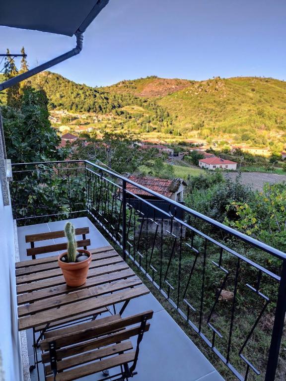 a balcony with a bench and a potted plant at Casa do Retornado in Covas do Barroso