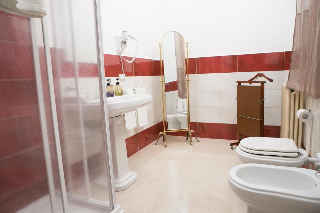 La salle de bains est pourvue d'un lavabo, de toilettes et d'une douche. dans l'établissement B&B The Queen, à Ispica