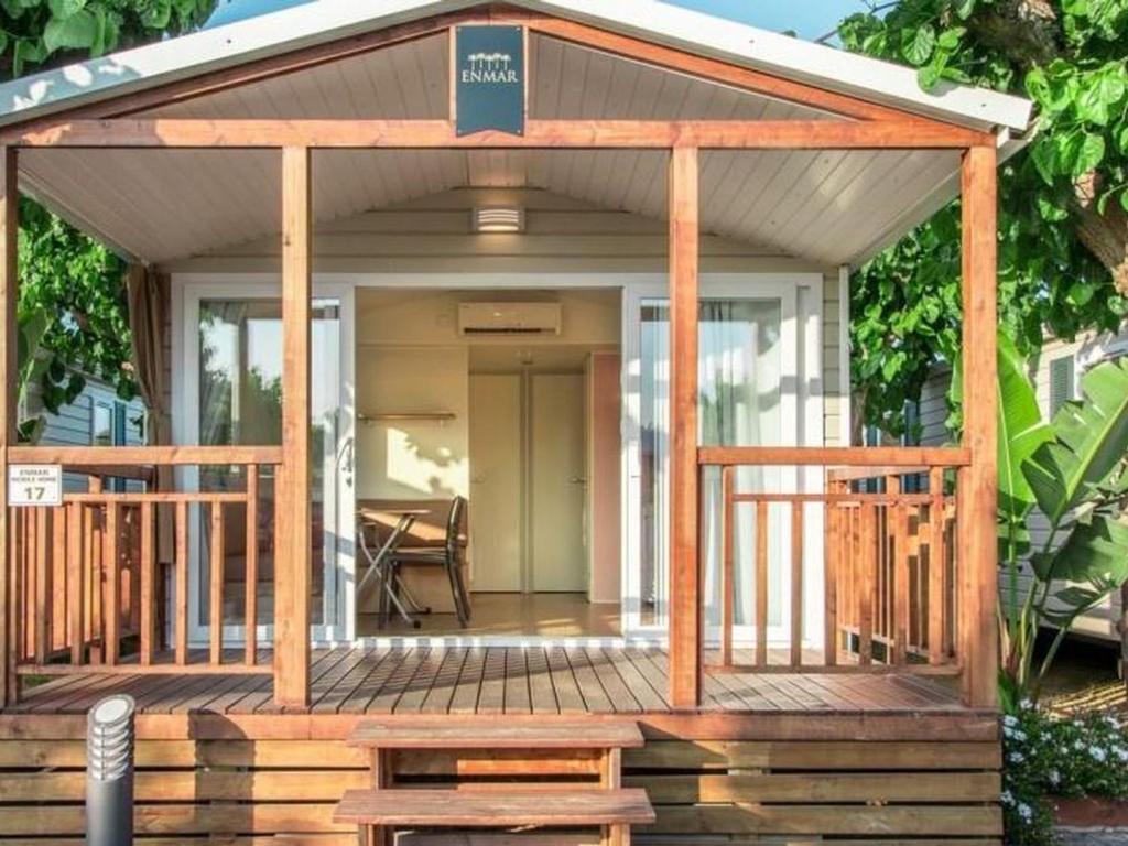 Saint-Martin-de-BremMobil-home 4 pers avec terrasse à Brem - API-1-52-438的带门廊和露台的小房子