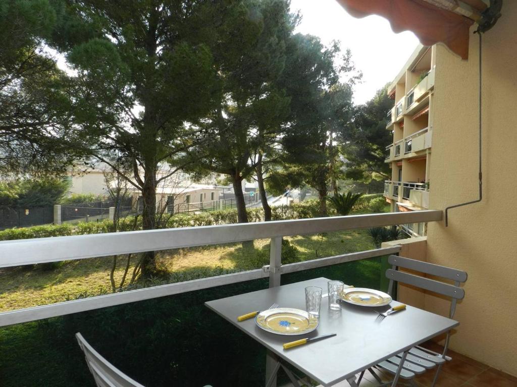 Una mesa y sillas en un balcón con vista. en Studio à Bormes-les-Mimosas avec balcon et parking privatif - FR-1-251-886, en La Favière