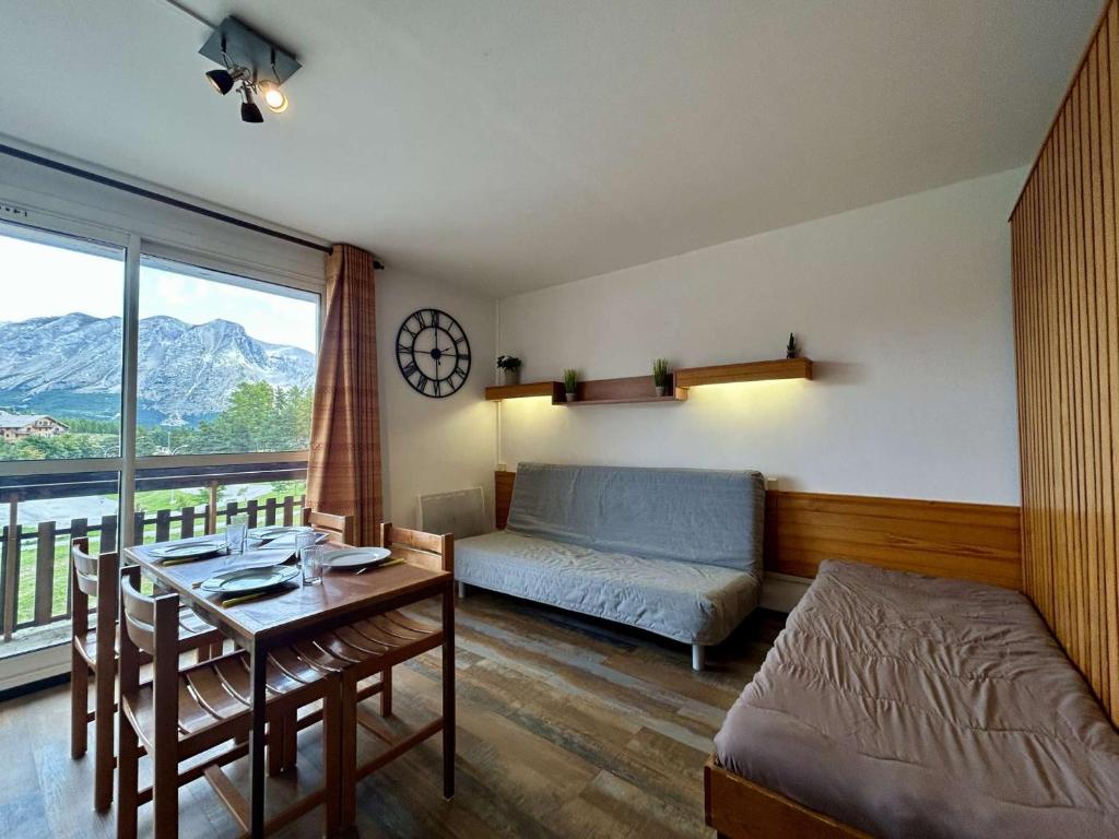 un soggiorno con un divano e un tavolo di Studio 4 pers. proche pistes, commerces, WiFi - FR-1-525-305 a Superdevoluy